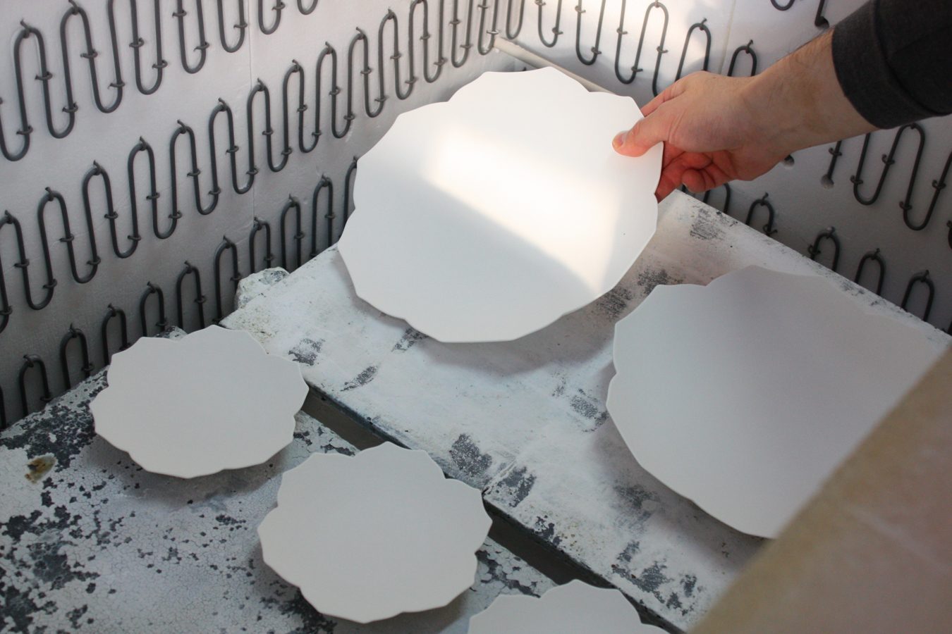 White plates laid out inside the kiln