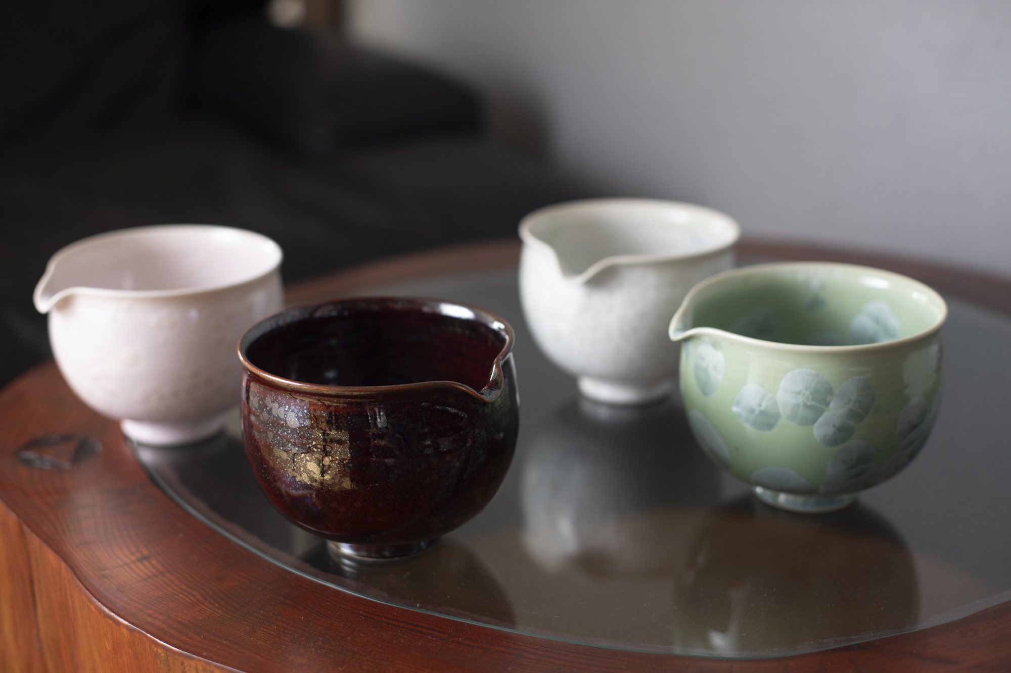 Four katakuchi pouring bowls on a wooden table
